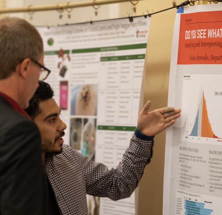 Nicholas Arevalo explaining his research poster to Roy Haggerty