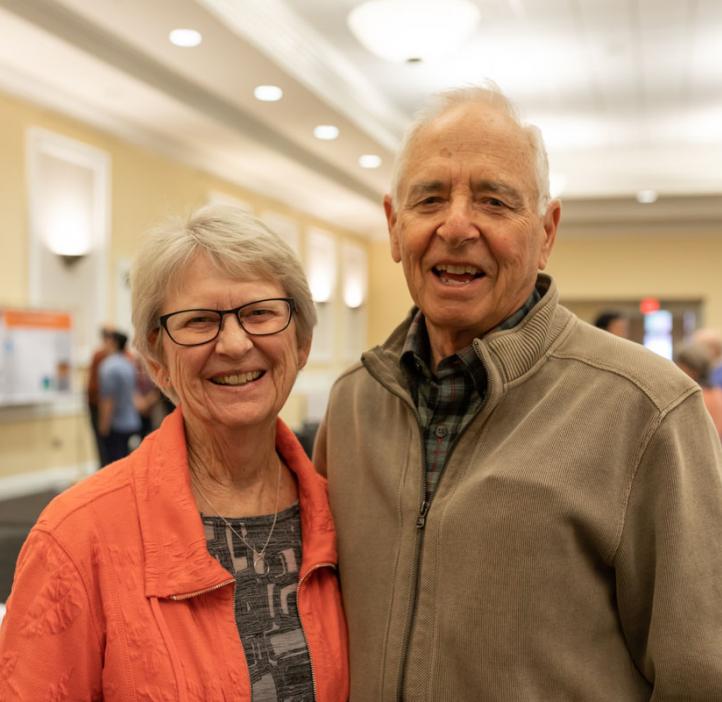 elderly couple hugging in lobby
