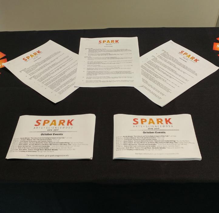 SPARK event flyers and cards on display at table