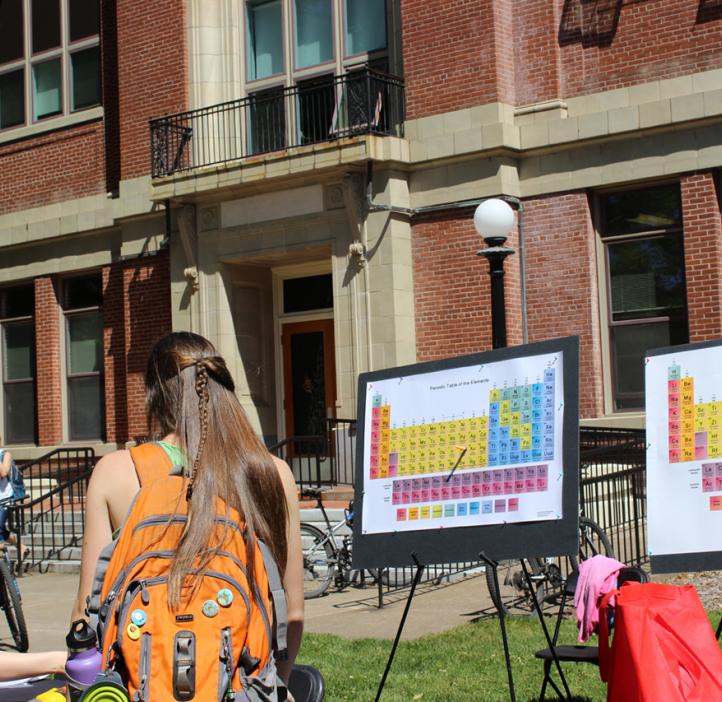 students shooting periodic table with nerf gun in front of Kidder Hall