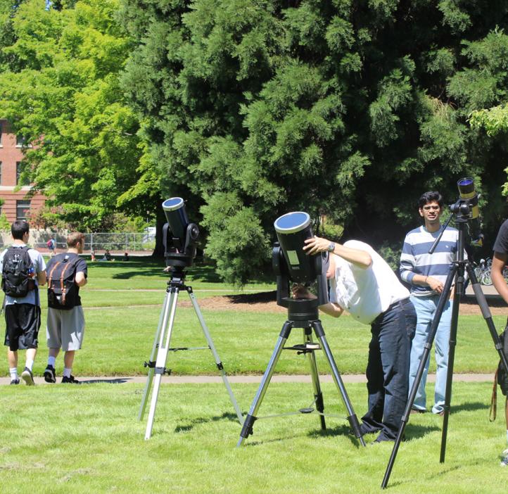 students and faculty looking though telescopes in Valley Library field