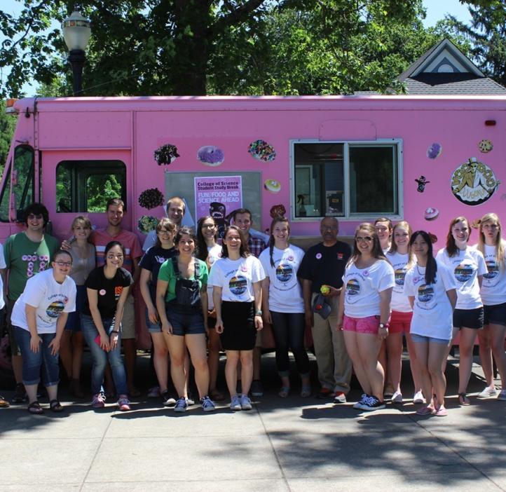 group photo of students and Sastry Pantula in front of pink Voodoo Doughnut truck