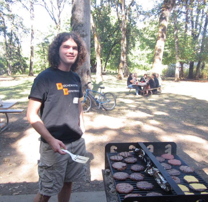 male student grilling burgers