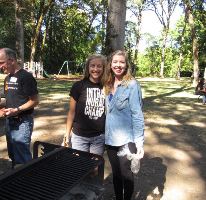 two female student hugging next to grill