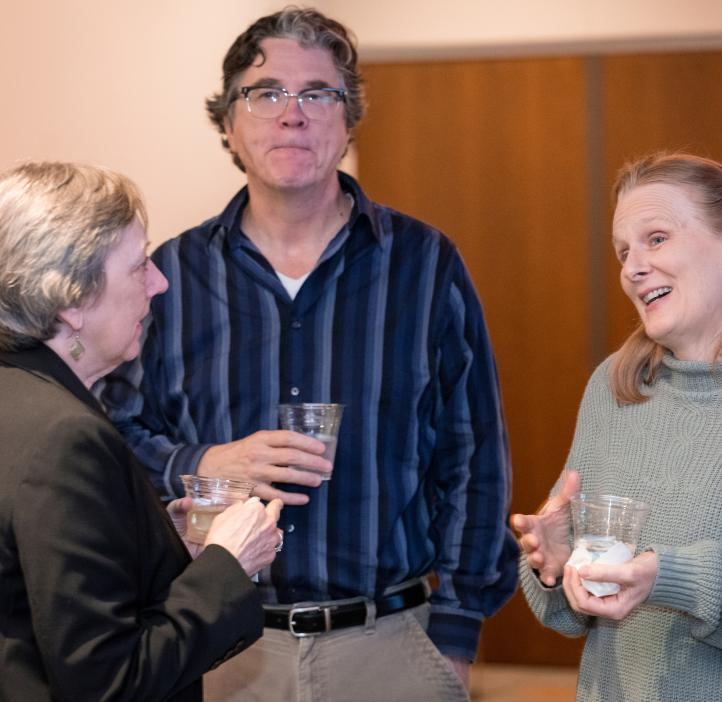 Three participants hold cups and engage in an exciting conversation during the 2024 Winter Awards Ceremony at Oregon State University.