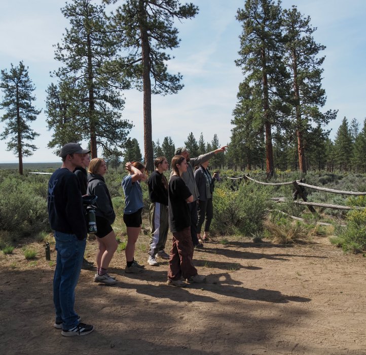 Students look into the distance as an instructor points.