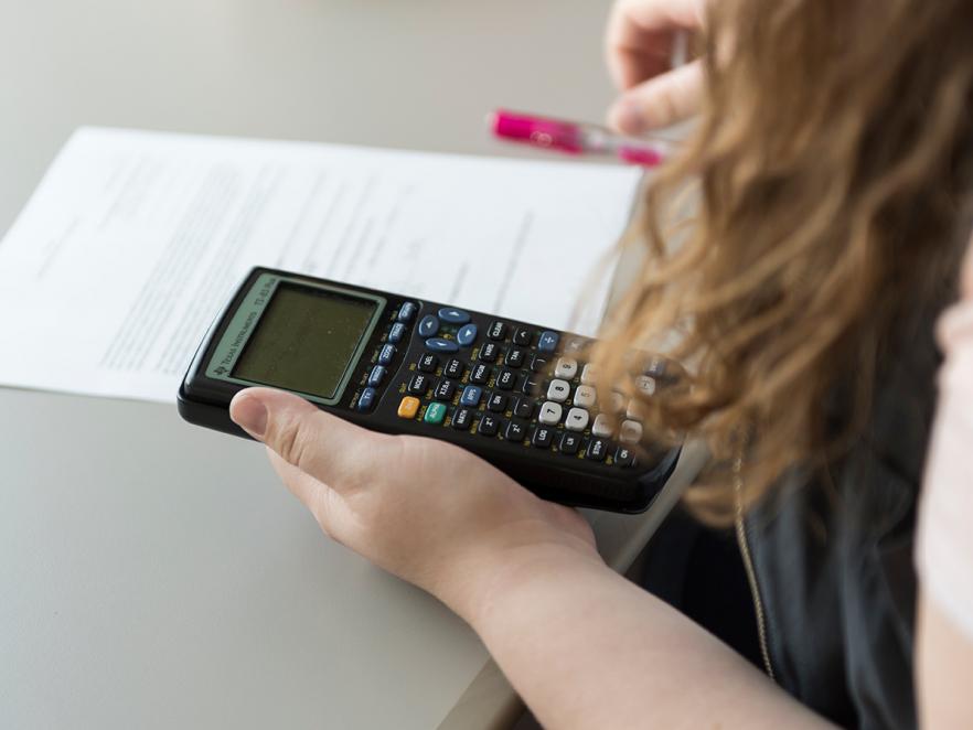 female student working on math on table