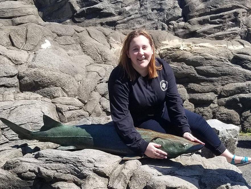 Brianna Anders holding large fish on rocky beach