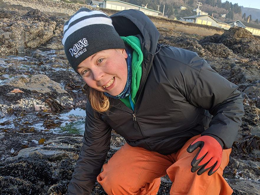 Jennifer Scoig collecting samples on rocky beach